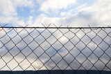 Metal fence background, real fence close-up and texture on sky background