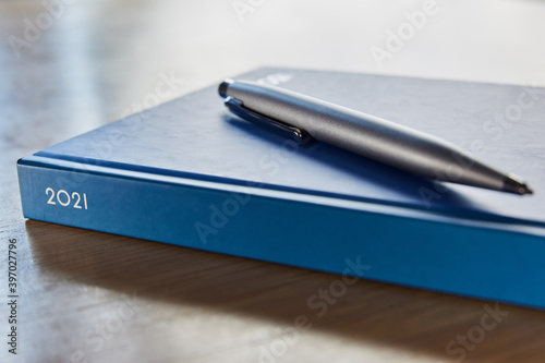 Close Up Of Pen Resting On 2021 Desk Diary On Table
