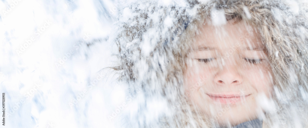 Child face with closed eyes smiling with blurred snow falling. Banner Child face with closed eyes smiling with blurred snow falling. Banner
