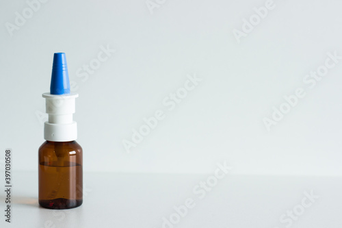 Nose spray with blue cap on white background; isolated; nasal spray; flu and cold remedy; medicine; covid-19; corona