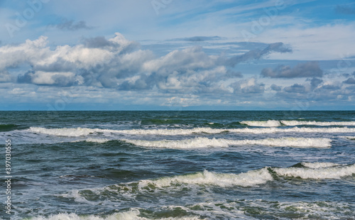 Tropical beach  small waves and blue sky with clouds