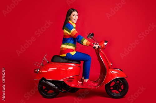 Profile side view of pretty cheerful girl driving moped fast speed having fun isolated over bright red color background