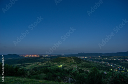 Panorama of a small night city taken from the mountain