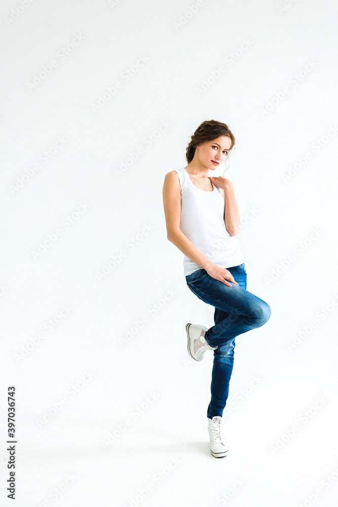 cheerful girl in a white t-shirt and dark blue jeans in the studio on a white background cheerful girl in a white t-shirt and dark blue jeans in the studio on a white background