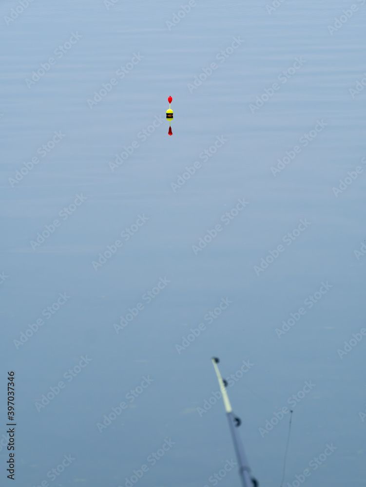 Orange fishing float or cork at the surface of the water.