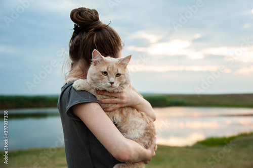 Photo of a girl holding a cat in the landscape photo