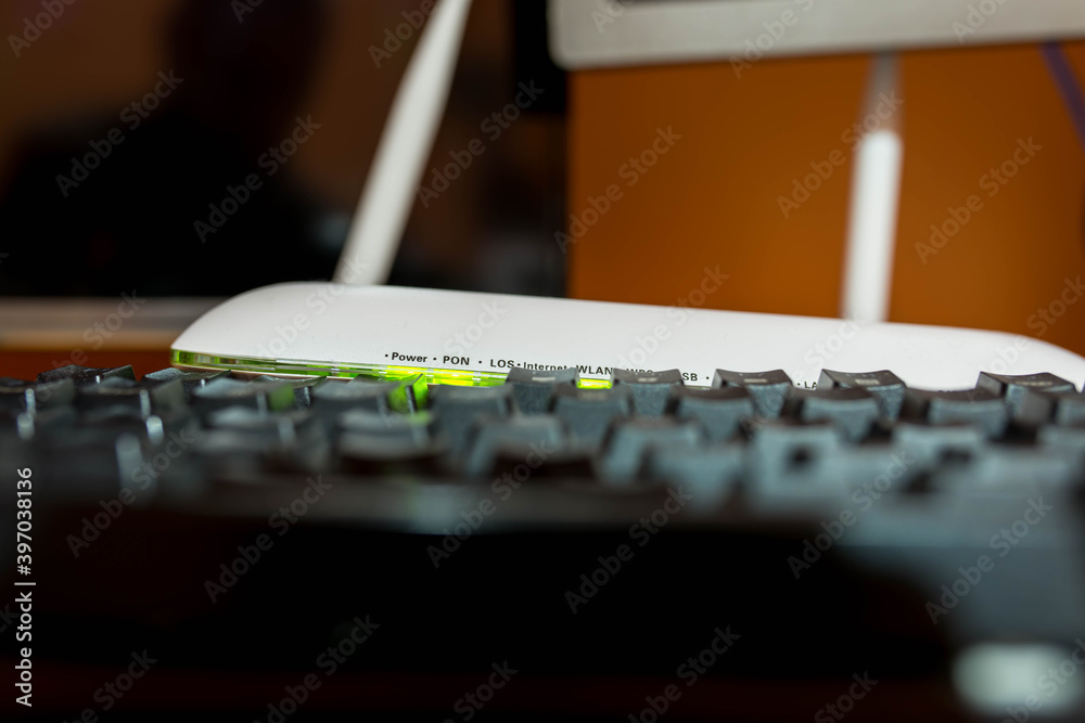 Blinking green lights on wifi router behind mechanical gaming keyboard