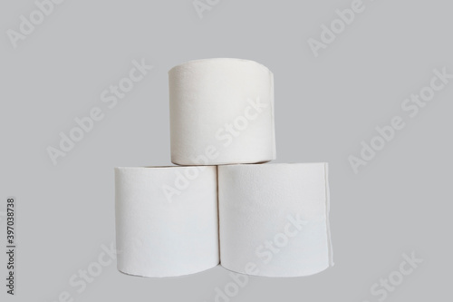 Stacks of rolls of toilet paper on white background