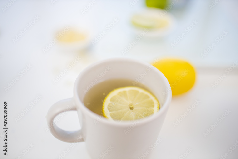 Cup of lemon tea on a table with limes and lemons Cup of lemon tea on a table with limes and lemons