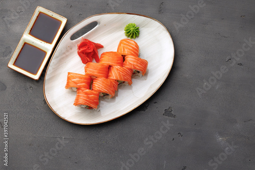 Top view of Philadelphia sushi roll on plate on black table