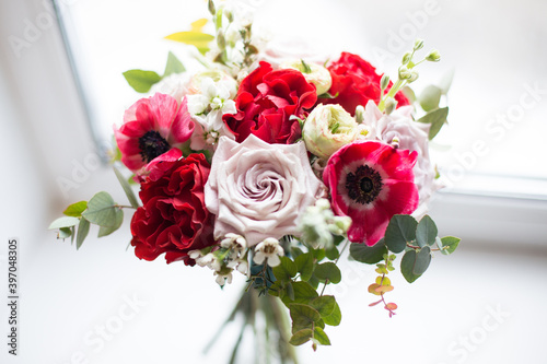 Fresh anemones and roses flowers on window background. Close up of bouquet with el toro roses, latin pompon roses, white matthiola and eucalyptus © Anastasiia