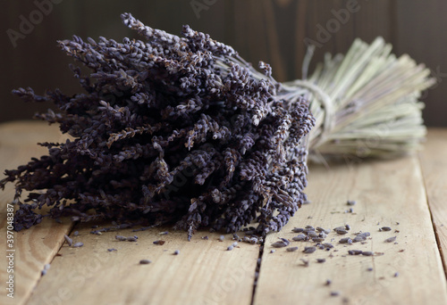 Lavender dry bouquet and dried herb buds nearby on rustic wooden table, closeup, copy space, natural cosmetics, aromatherapy and naturopathy concept