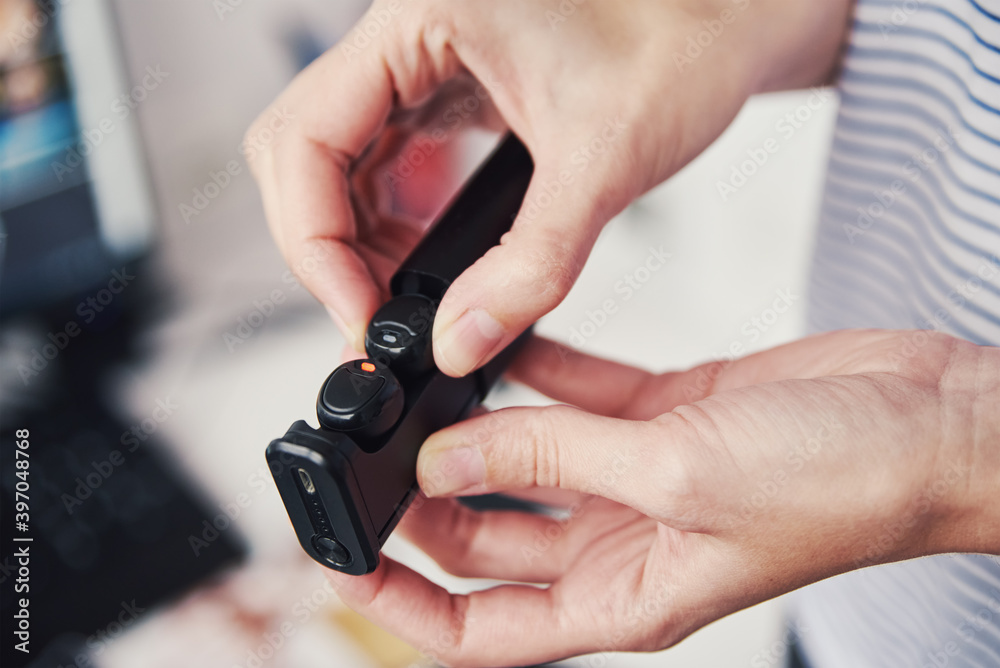 Fototapeta premium Woman take out wireless earphones from a case. Using headphones for listening music