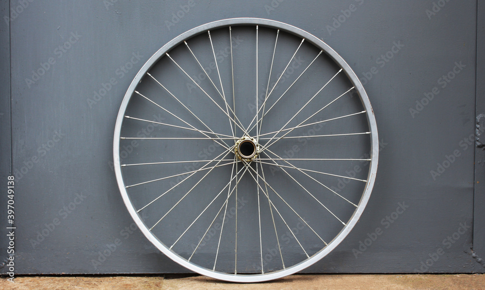 Gray bicycle disc. Bicycle wheel on a gray background. Place for text. Selective focus. Gray bicycle disc. Bicycle wheel on a gray background. Place for text. Selective focus.