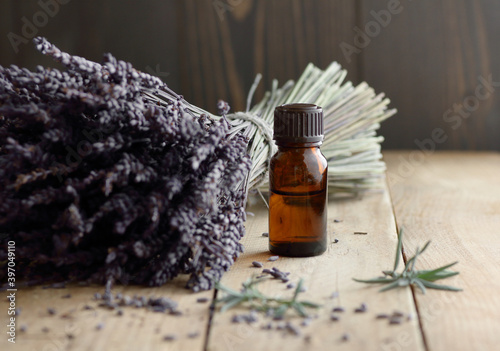 Canvas Print Lavender essential oil in the bottle with lavender bouquet and herb leaves nearb