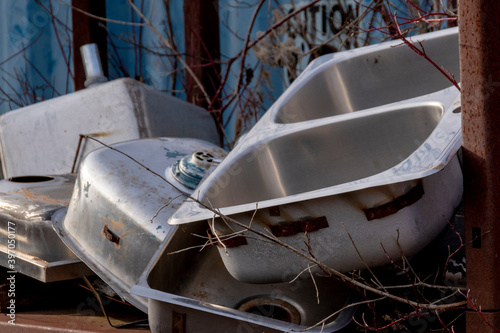 A selection of old sinks is piled high in the trash at the back of a building near Rockwood, Ontario. photo