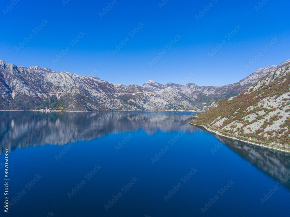 Beautiful fjord of Montenegro. Calm in the Bay of Kotor. Reflection of mountains on water.