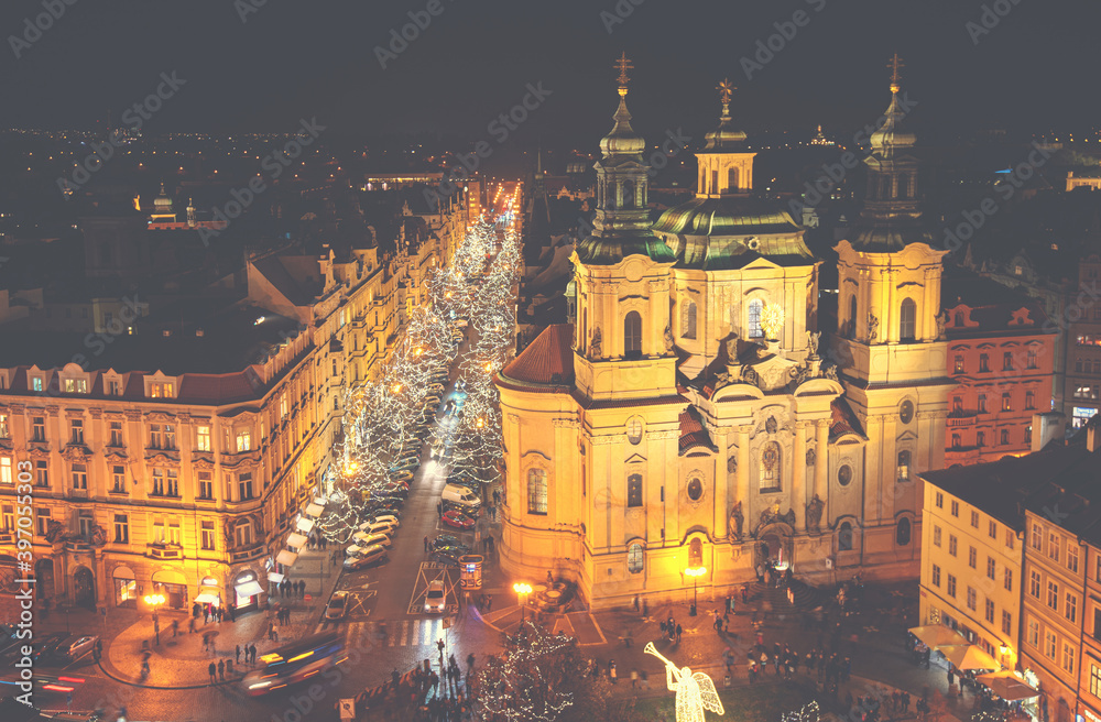 Aerial view of Old Town square with illuminated St. Nicholas' Church, a hussite place of worship built in the 12 century in Prague, Czechia.