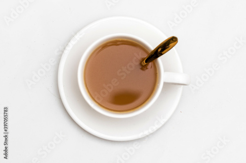 White cup of tea and herbal beverage, Top view, golden spoon, isolated white background
