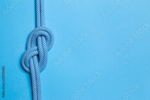 Eight knot on a rope on a blue background. Copy space.