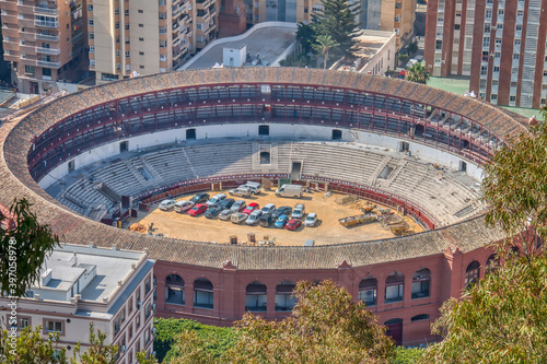 Malaga's bullring under construction, full of parked cars.