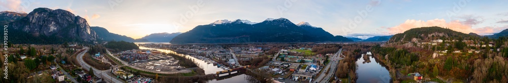 Aerial Panoramic View of Residential Homes, Sea to Sky Highway and Shopping Mall. Colorful Sunset Sky. Taken in Squamish, North of Vancouver, British Columbia, Canada.