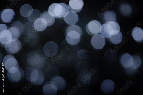 Abstract pattern of white bokeh lights on a dark background