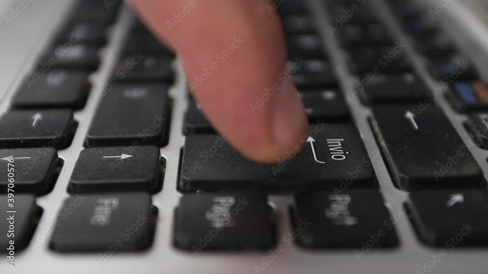 Close-up, man's finger presses the enter key on the notebook keyboard