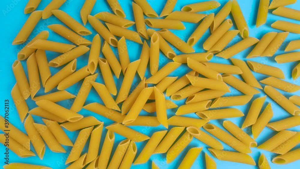 Animated raw pasta on a blue background, top view. Stop motion animation of a large amount of pasta. Animated raw pasta on a blue background, top view. Stop motion animation of a large amount of pasta.