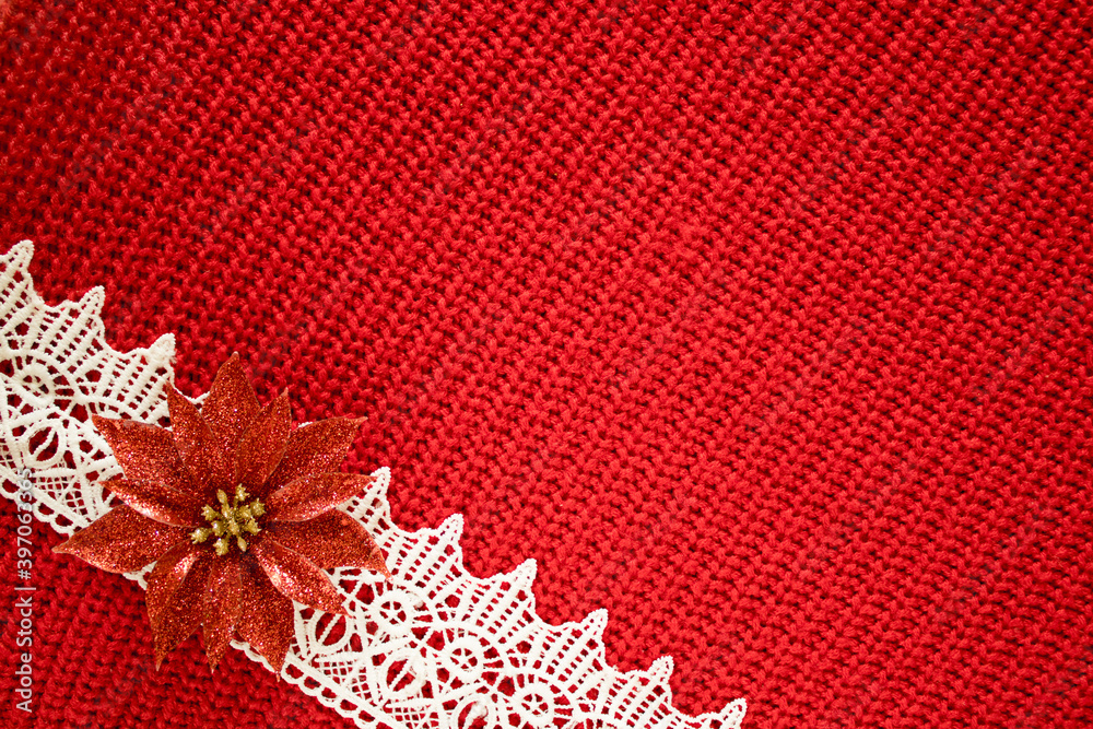 Greeting card with background of knitted wool texture with lace and decorative flower. Seasonal seamless background for christmas holiday design. Copy space for your text.