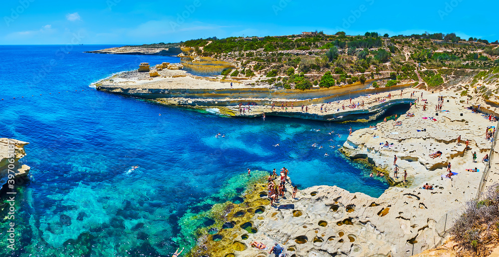 The rocky Delimara coast and azure waters of St Peter Pool, Marsaxlokk, Malta