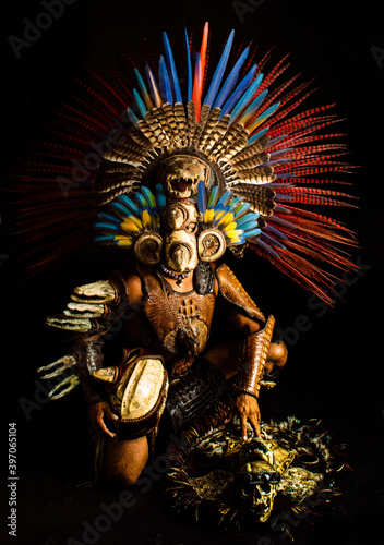 guerrero azteca danzante con penacho en fondo negro claro oscuro