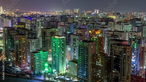 Aerial skyline of Abu Dhabi city centre from above during all night timelapse with illuminated skyscrapers and blinking light in windows photo