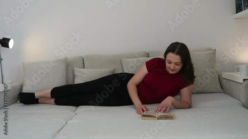 Young, attractive woman reading a book in her living room. Relax concept. 