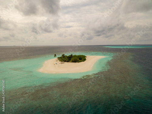 Aerial spherical panorama of tropical paradise beach on tiny Maldives island. Turquoise ocean, white sand, coconut palm trees.