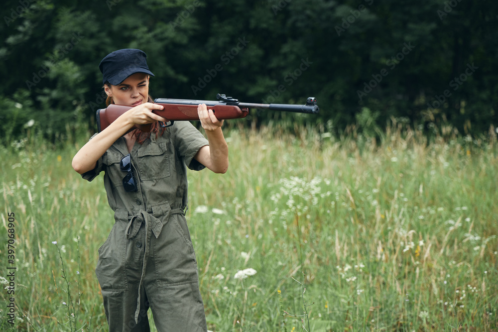 Fototapeta premium Woman soldier Holds a weapon aiming at a green jumpsuit weapons 