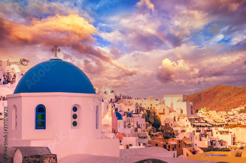 Oia town, Santorini Cyclade islands, Greece. Beautiful sunset with a rainbow over the vilage of Ia.