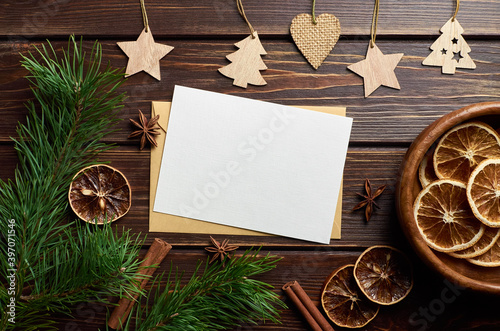 Christmas greeting card mockup with dry oranges, christmas spices and decorations on dark wooden background