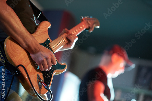 Rock musician playing electric guitar at a concert in a club