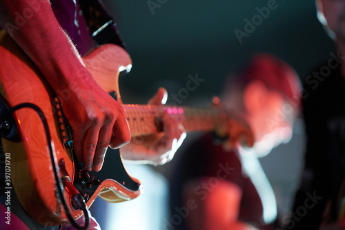 Rock musician playing electric guitar at a concert in a club