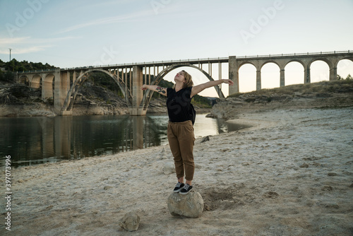 woman in a lake with a bridge