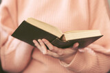 Girl reading book, woman holding open book, toned picture