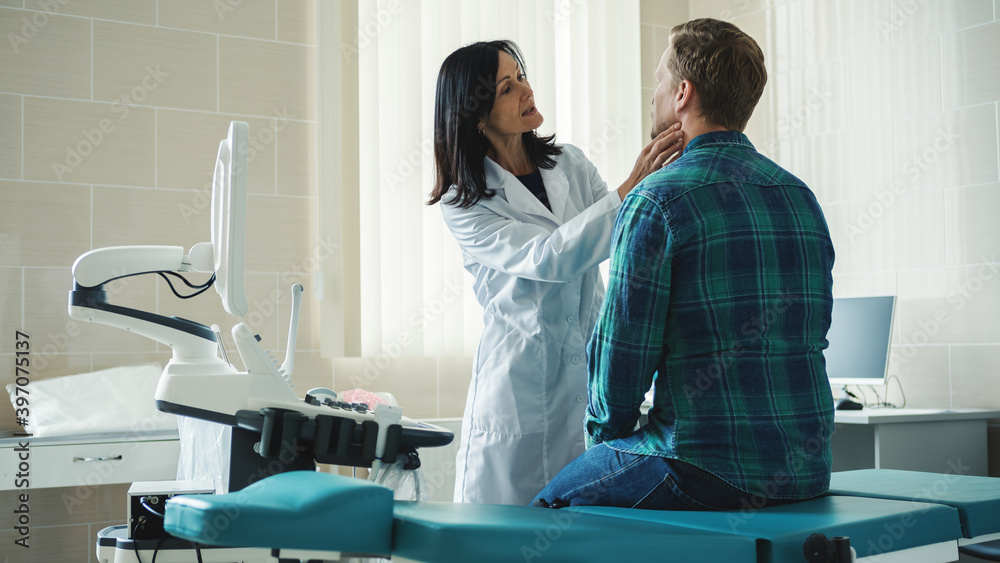 © Comeback Images - Female doctor in white coat checking lymph nodes or tonsils of middle aged male patient sitting on couch in front of her