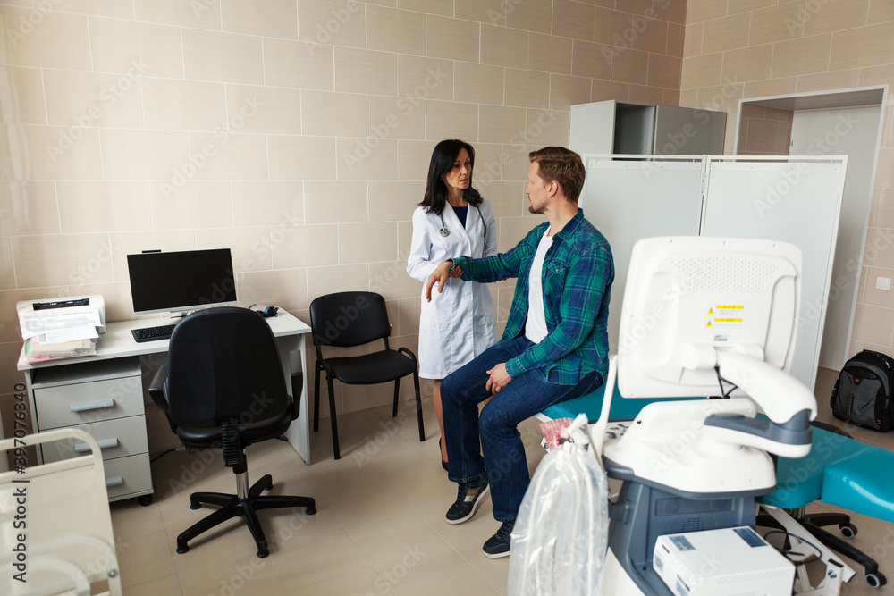 Female doctor in white coat checking arm of male patient sitting on couch and asking about symptoms Female doctor in white coat checking arm of male patient sitting on couch and asking about symptoms