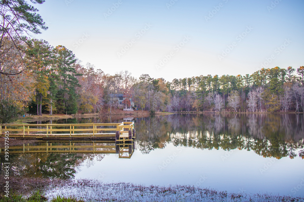 A calm lake and dock with reflections in the Fall