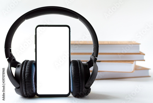 phone and headphones in the background of books. concept choice of technology or classics. photo