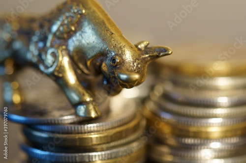 Metal bull with coins on the table. Financial symbol.