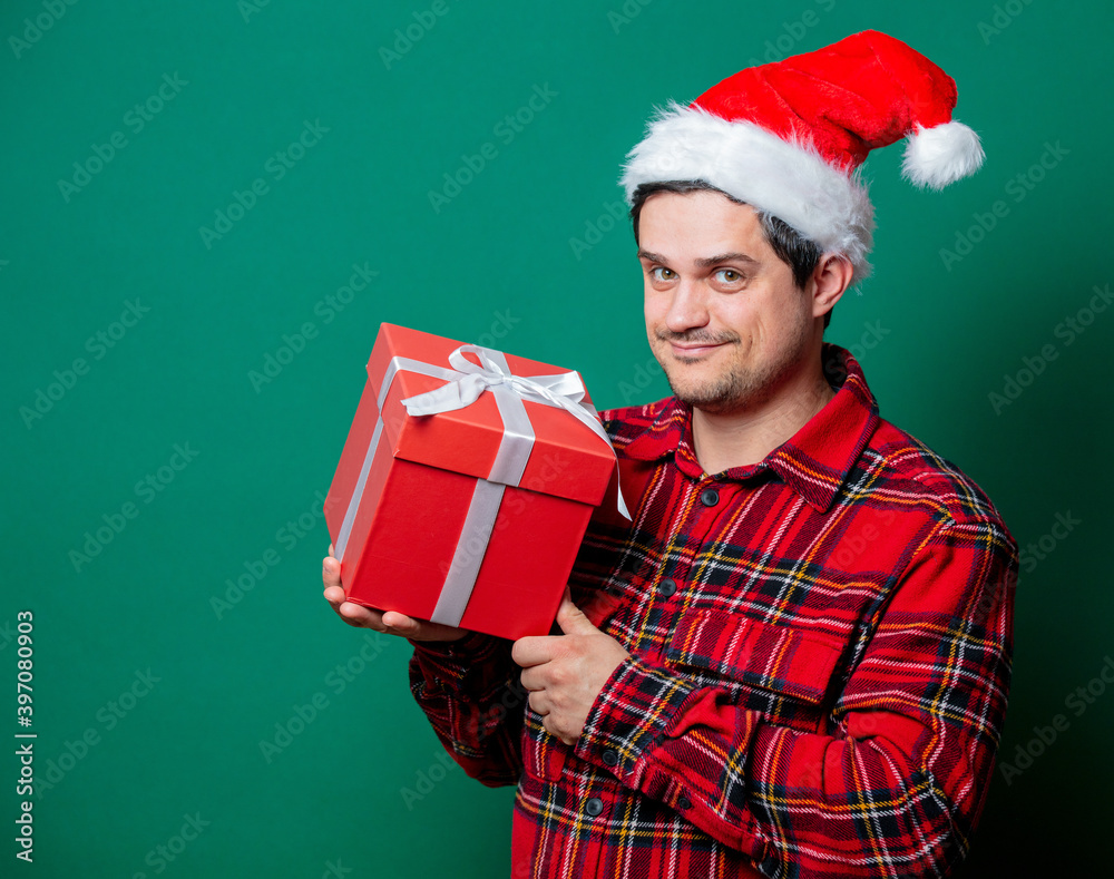 Guy in Christmas hat and tartan shirt with gift box Guy in Christmas hat and tartan shirt with gift box