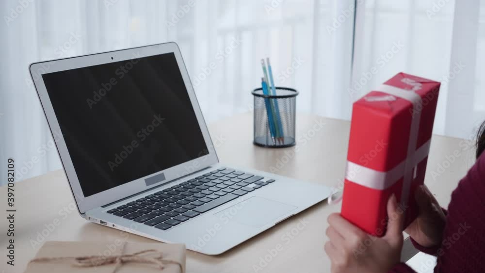 Young asian woman self video call online with friend and show gift box in Christmas day on laptop computer with green screen blank display, social distancing, new normal, communication concept. Young asian woman self video call online with friend and show gift box in Christmas day on laptop computer with green screen blank display, social distancing, new normal, communication concept.
