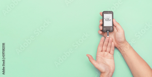 Man using glucometer, checking blood sugar level photo